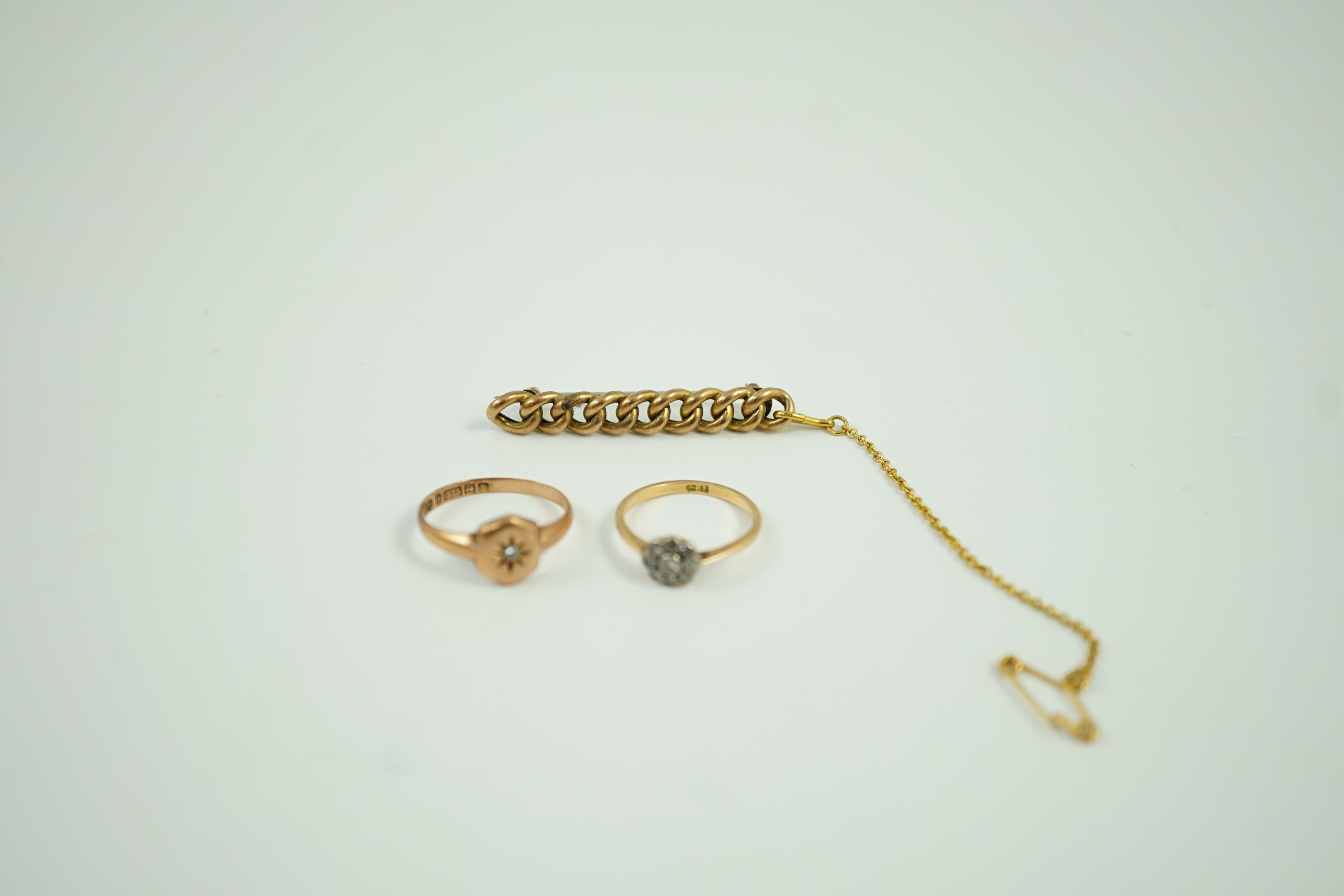 A small 18ct and diamond set cluster ring, size K, gross 1.2 grams, a 9ct gold and diamond chip set ring and a yellow metal curb link bar brooch, gross 5.1 grams.
